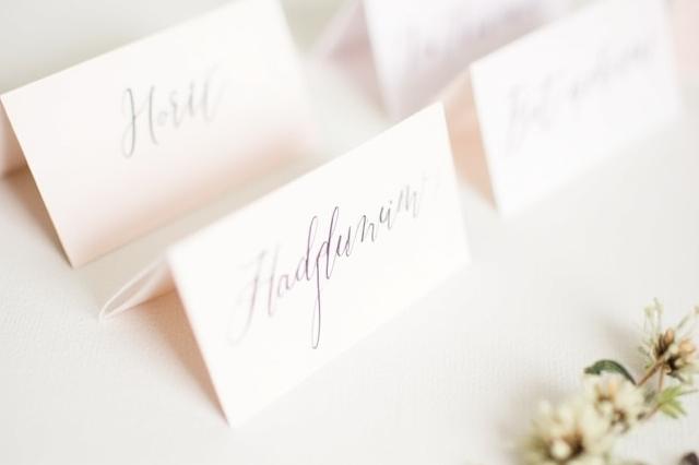 Custom event place cards with guest names in calligraphy.